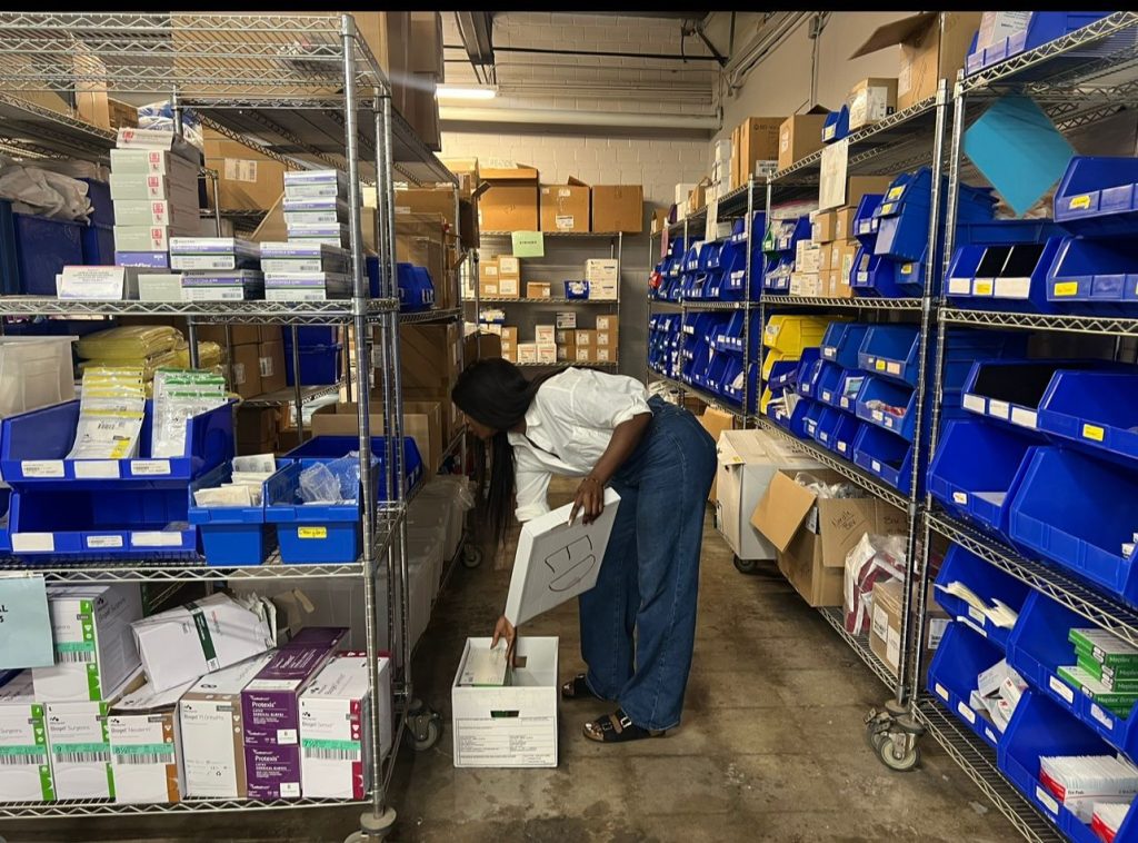 Tosin Ilesanmi, President of ACCG Foundation, inspecting donated medical equipment before shipment to Nigeria.