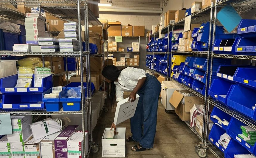 Tosin Ilesanmi, President of ACCG Foundation, inspecting donated medical equipment before shipment to Nigeria.